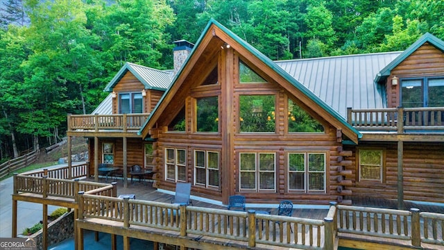 rear view of property featuring a wooden deck