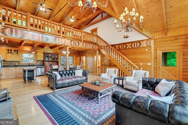 living room featuring light hardwood / wood-style floors, a notable chandelier, wooden walls, high vaulted ceiling, and wooden ceiling