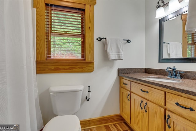 bathroom with vanity, toilet, and hardwood / wood-style flooring