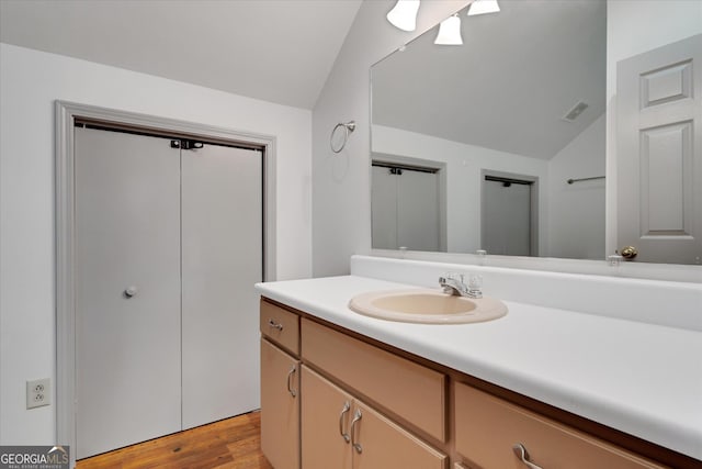 bathroom featuring lofted ceiling, vanity, and hardwood / wood-style floors