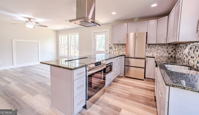 kitchen featuring island exhaust hood, appliances with stainless steel finishes, sink, and white cabinetry