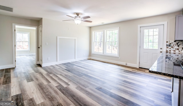 unfurnished living room featuring ceiling fan and light hardwood / wood-style flooring