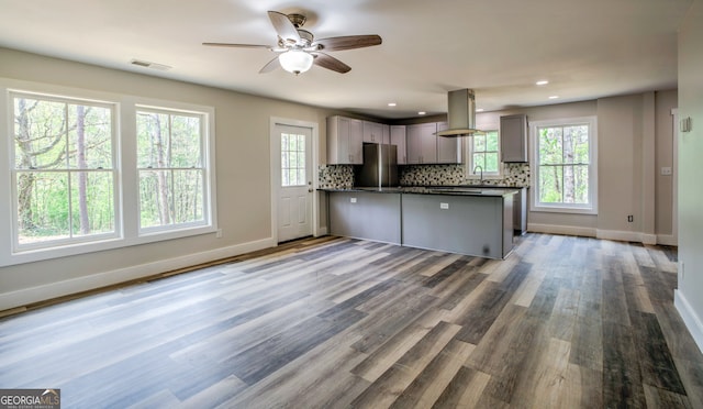 kitchen with gray cabinets, island exhaust hood, plenty of natural light, and stainless steel fridge