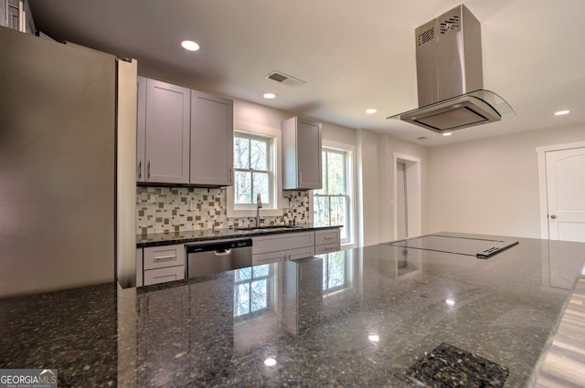 kitchen with sink, stainless steel dishwasher, island range hood, black cooktop, and dark stone counters