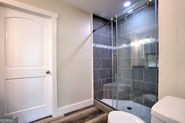 bathroom with an enclosed shower, hardwood / wood-style floors, and toilet