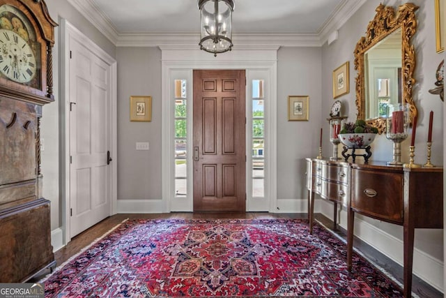 entryway with ornamental molding and a notable chandelier