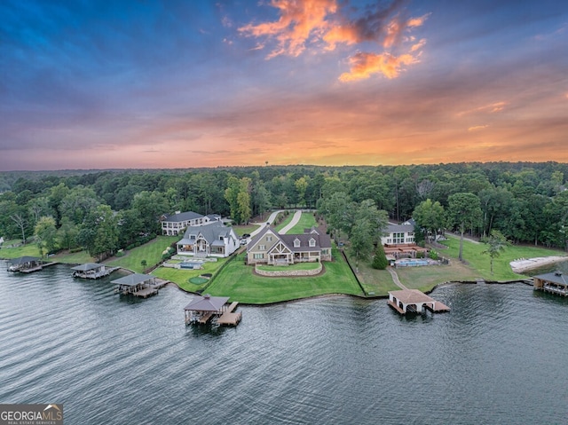 aerial view at dusk featuring a water view