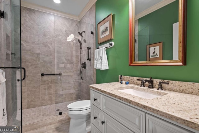 bathroom with ornamental molding, an enclosed shower, vanity, and toilet