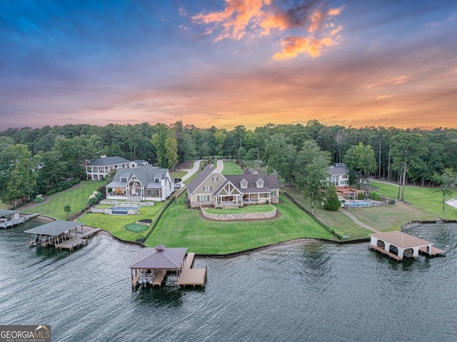 aerial view at dusk featuring a water view