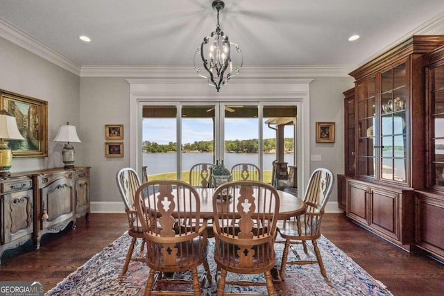 dining space featuring crown molding, an inviting chandelier, dark hardwood / wood-style floors, and a water view