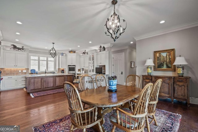 dining area with ornamental molding, dark hardwood / wood-style flooring, and a chandelier