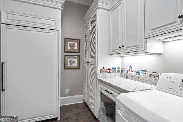 laundry room featuring washer / dryer, cabinets, and ornamental molding