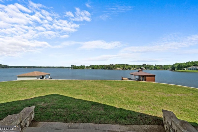 view of dock featuring a lawn and a water view