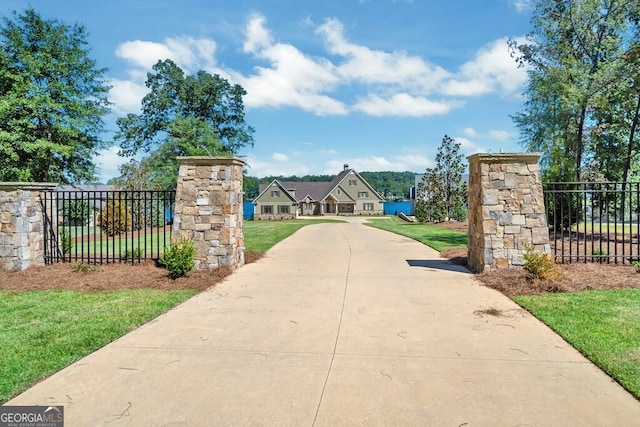 view of gate with a lawn