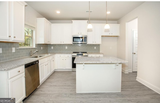 172 Chapman Rdg, Macon, GA 31211 - kitchen with stainless steel appliances, a sink, light wood-style floors, a kitchen island, and baseboards