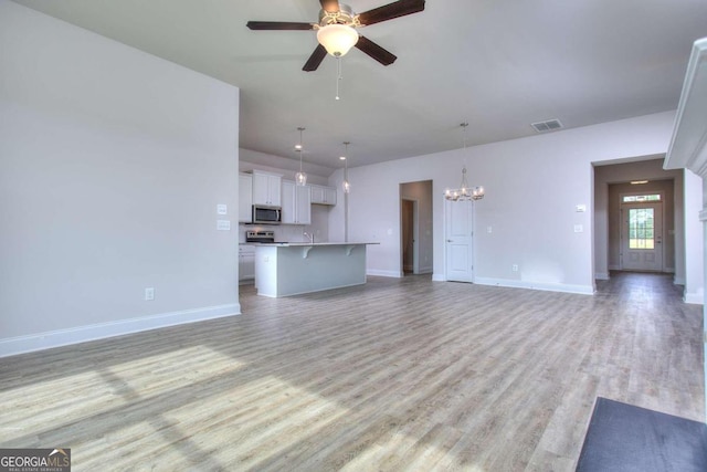 168 Chapman Ridge Rd, Macon, GA 31211 - unfurnished living room with a chandelier, light wood-style floors, a ceiling fan, and baseboards