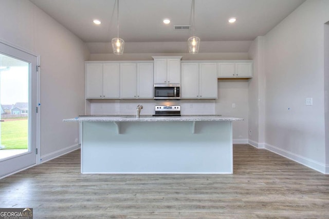 168 Chapman Ridge Rd, Macon, GA 31211 - kitchen featuring stainless steel appliances, white cabinetry, a center island with sink, a breakfast bar area, and hanging light fixtures