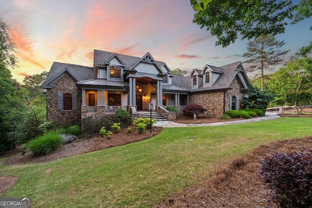 view of front of home with a porch and a lawn