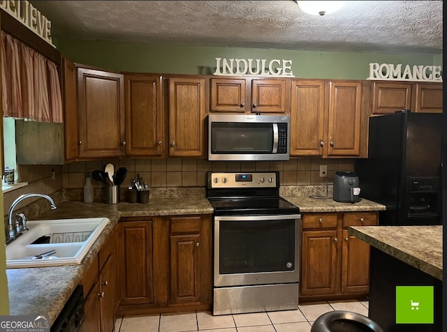 kitchen featuring sink, tasteful backsplash, light tile flooring, and black appliances