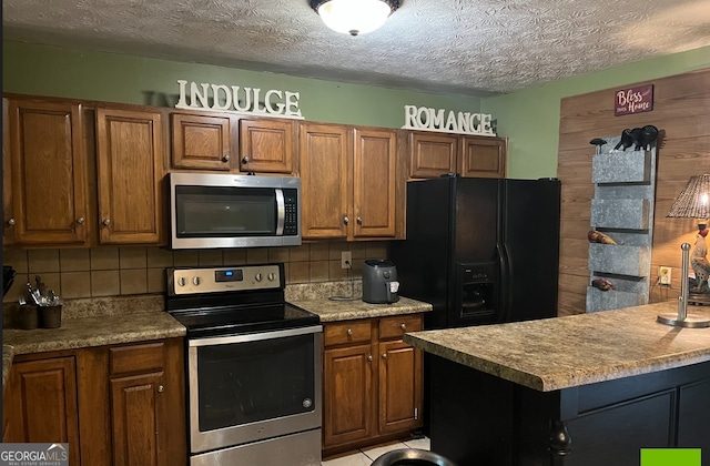 kitchen with a textured ceiling, tasteful backsplash, and stainless steel appliances