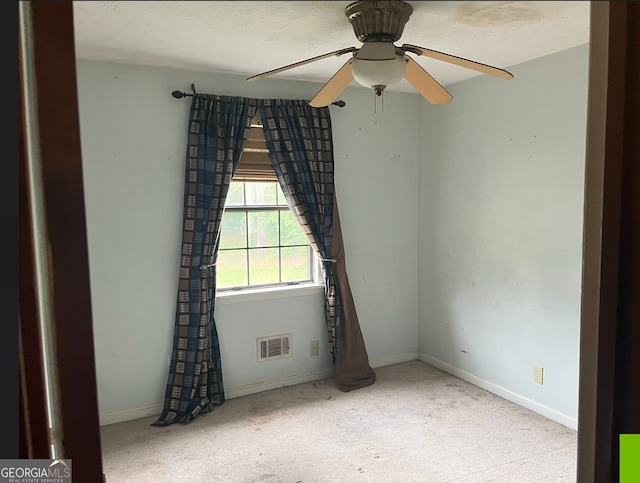 carpeted spare room featuring ceiling fan