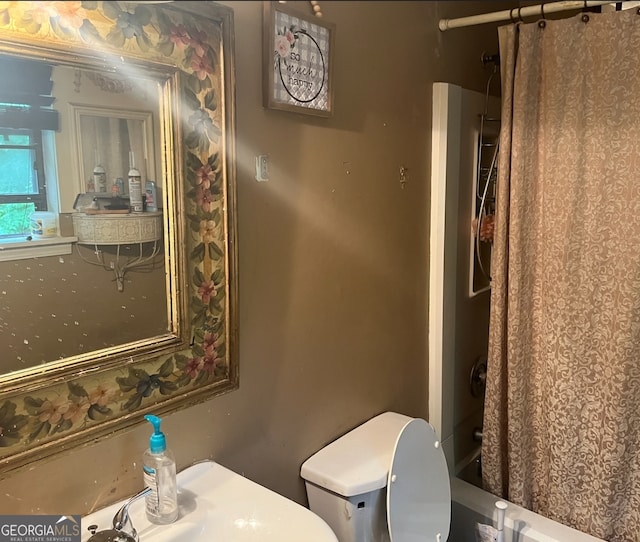 bathroom with toilet and shower / bath combo with shower curtain