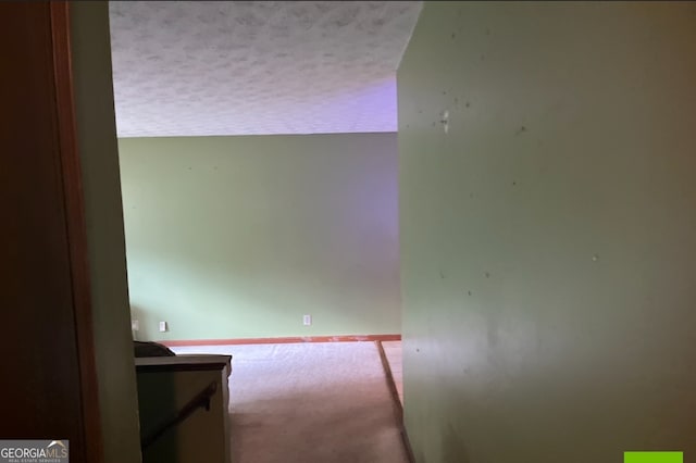 hallway featuring a textured ceiling and carpet floors