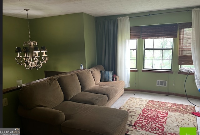 carpeted living room with a textured ceiling and a notable chandelier