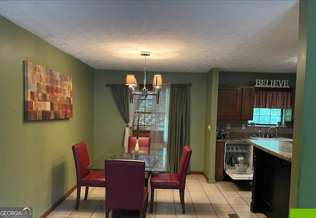 tiled dining space with a textured ceiling, sink, and a notable chandelier