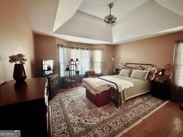 bedroom featuring a tray ceiling and hardwood / wood-style floors