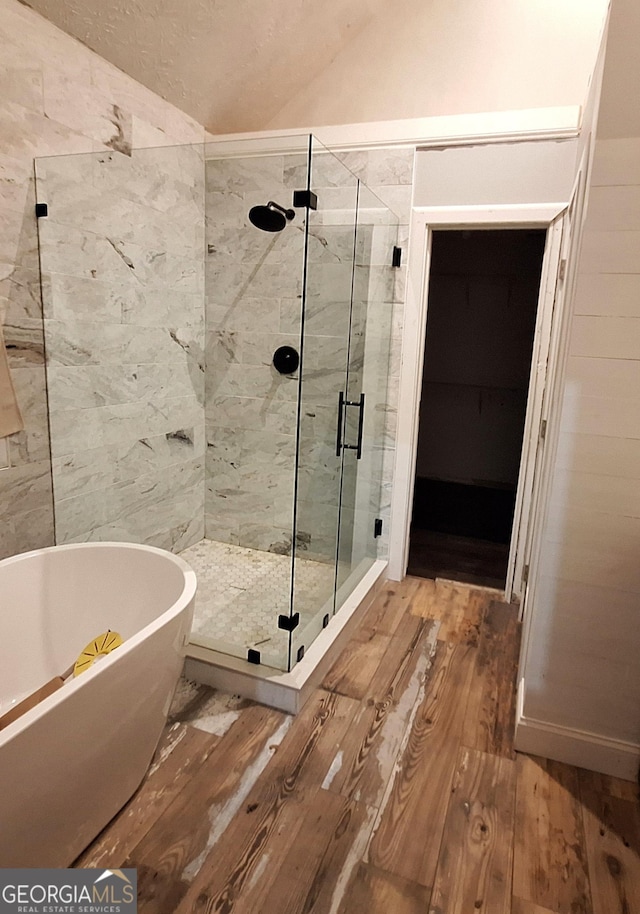 bathroom with wood-type flooring and shower with separate bathtub