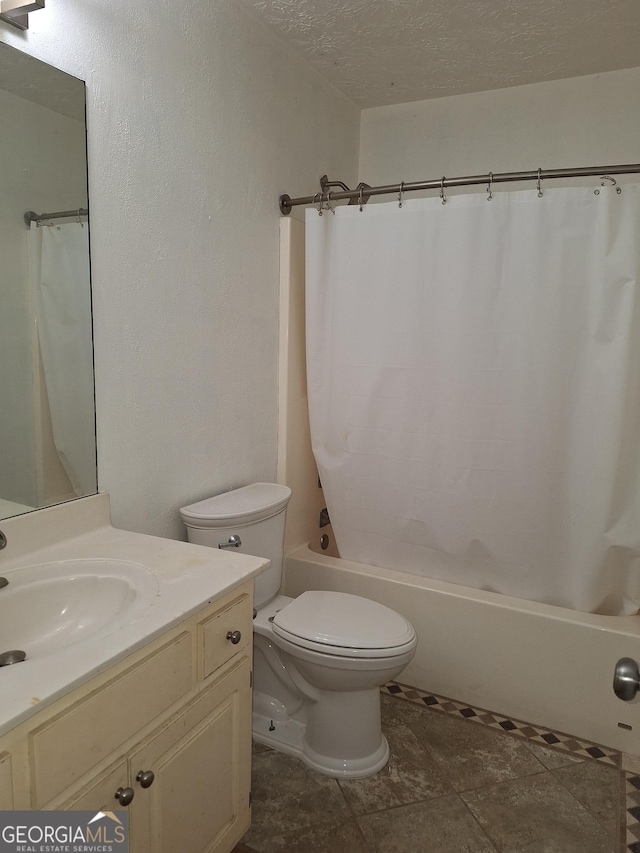 full bathroom with vanity, shower / bath combo, toilet, and a textured ceiling