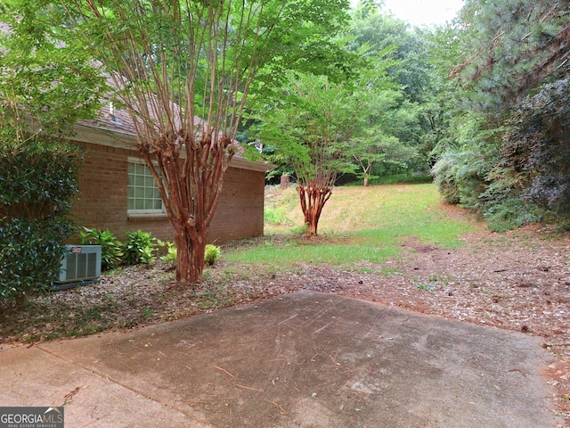 view of yard featuring central AC unit and a patio