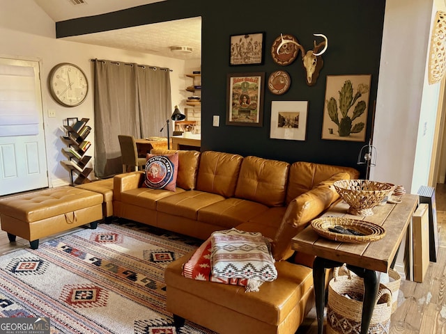 living room featuring lofted ceiling and hardwood / wood-style floors