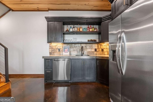 interior space featuring appliances with stainless steel finishes, wood ceiling, sink, and backsplash