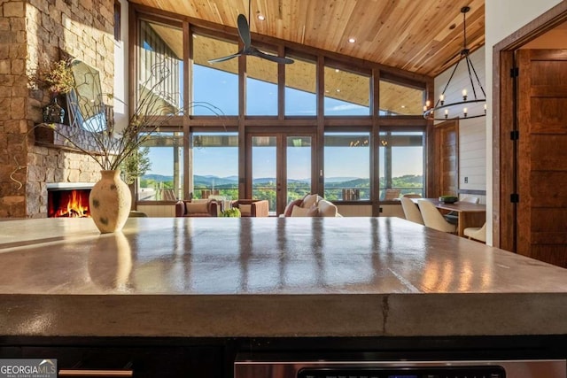 kitchen with high vaulted ceiling, wooden ceiling, and a fireplace