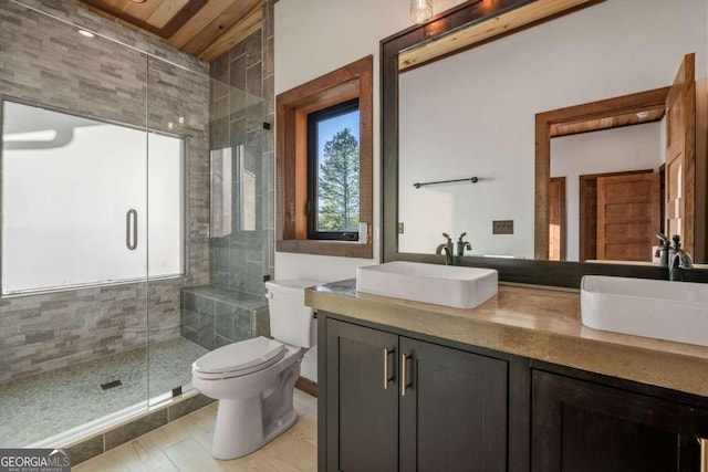 bathroom with a shower with shower door, vanity, toilet, and tile flooring