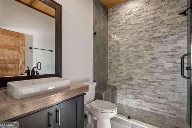 bathroom featuring a shower with shower door, toilet, tile floors, and vanity