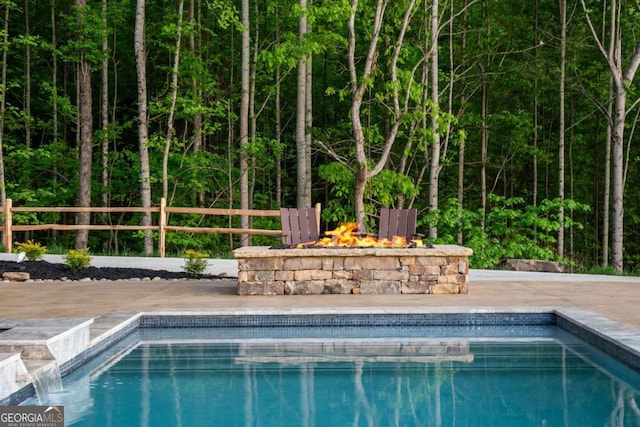 view of swimming pool with a fire pit and pool water feature