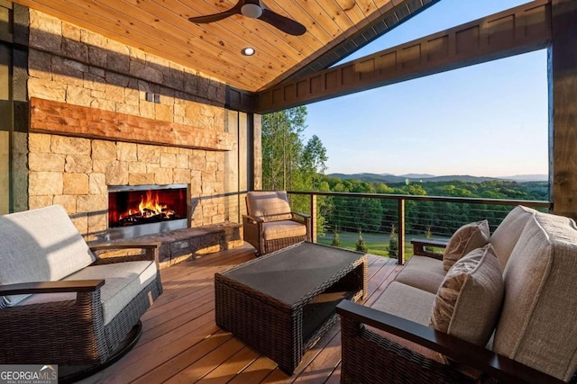 wooden deck featuring an outdoor living space with a fireplace and ceiling fan