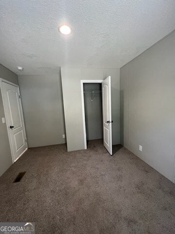 unfurnished bedroom featuring a closet, carpet, and a textured ceiling