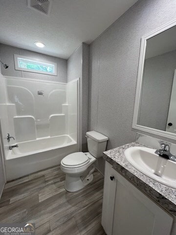 full bathroom with shower / washtub combination, toilet, oversized vanity, and hardwood / wood-style flooring