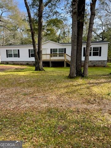 view of front facade featuring a wooden deck and a front lawn