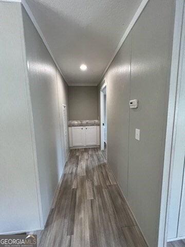 corridor featuring crown molding and hardwood / wood-style flooring