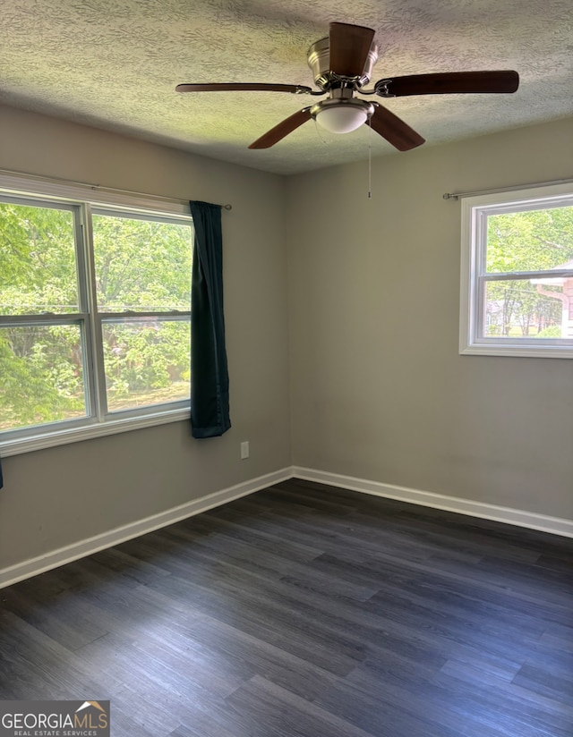 unfurnished room with dark wood-type flooring, ceiling fan, a textured ceiling, and plenty of natural light