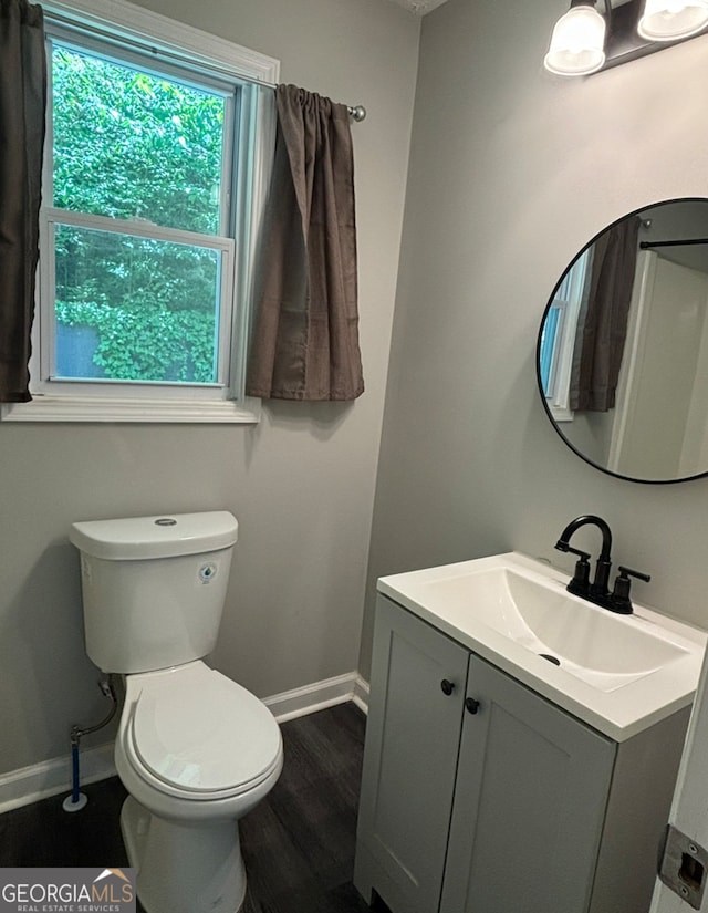 bathroom with vanity, toilet, and hardwood / wood-style floors