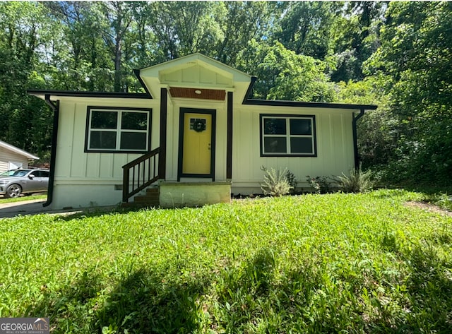 bungalow-style home with a front yard