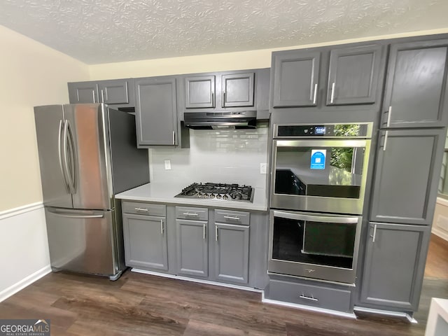 kitchen featuring appliances with stainless steel finishes, tasteful backsplash, and dark hardwood / wood-style floors