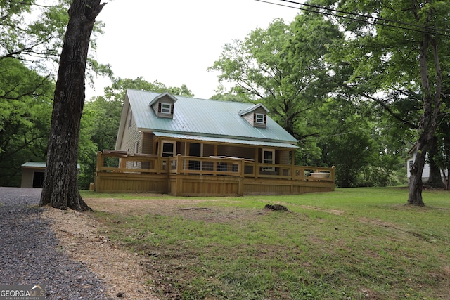 rear view of property featuring a wooden deck and a lawn