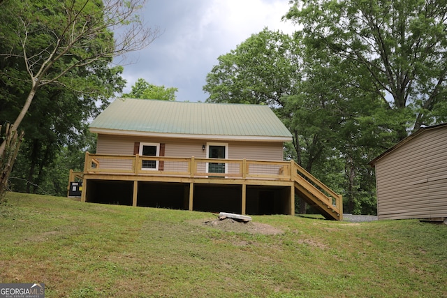 rear view of property featuring a deck and a lawn